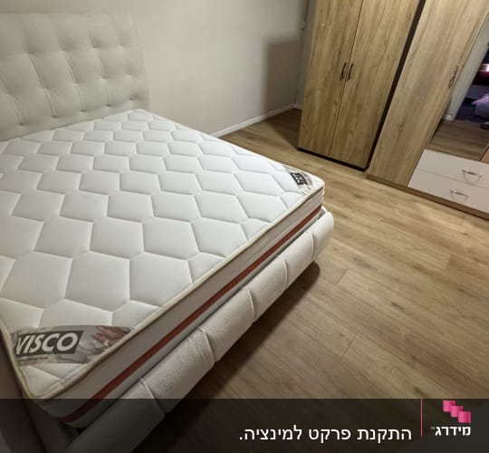 רצפת פרקט עץ בחדר שינה עם מיטה וארון